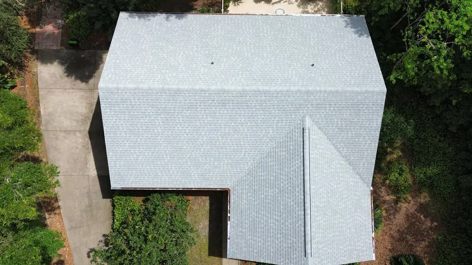 New light gray asphalt shingle roof on an L-shaped house, seen straight down from above