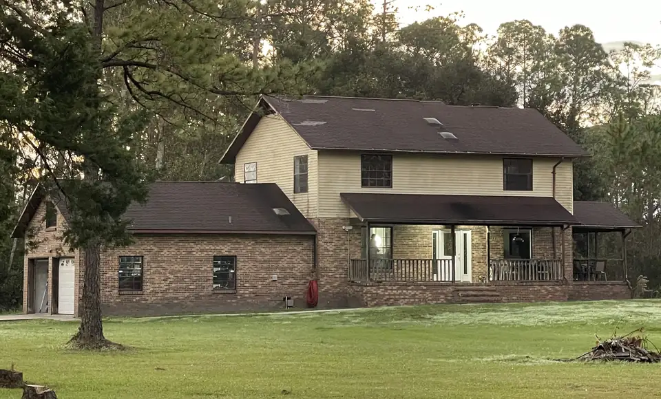 Cream house with old brown shingle roof, before